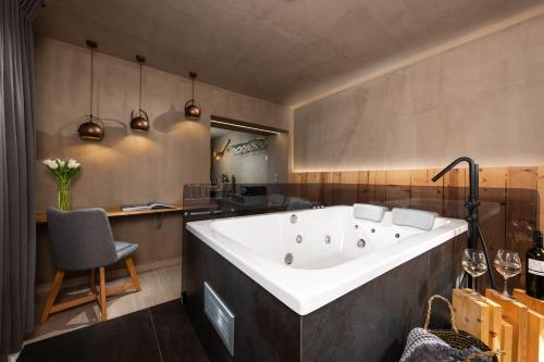 a large bath tub in a kitchen with a chair at Tsikeli Boutique Hotel Meteora - Adults Friendly in Kalabaka