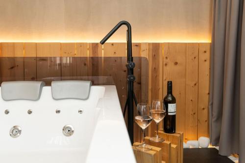 a bath tub with a bottle of wine and two glasses at Tsikeli Boutique Hotel Meteora - Adults Friendly in Kalabaka