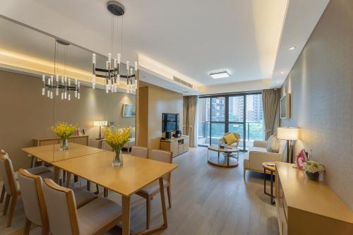 a dining room and living room with a table and chairs at CM Serviced Apartment in Shenzhen