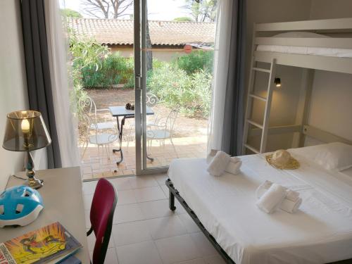 een slaapkamer met een bed en uitzicht op een patio bij ULVF Les Residences du Colombier in Fréjus