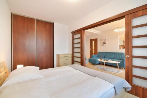 コウォブジェクにあるApartamenty Tit Kasprowiczaのベッドルーム(ベッド1台、青いソファ付)
