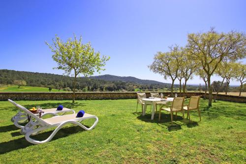 a table and chairs in the grass with a table and chairs at Villa Son Pons by Slow Villas in Llucmajor