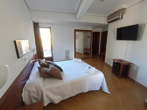 a bedroom with a large white bed in a room at Hotel ELE Acueducto in Segovia