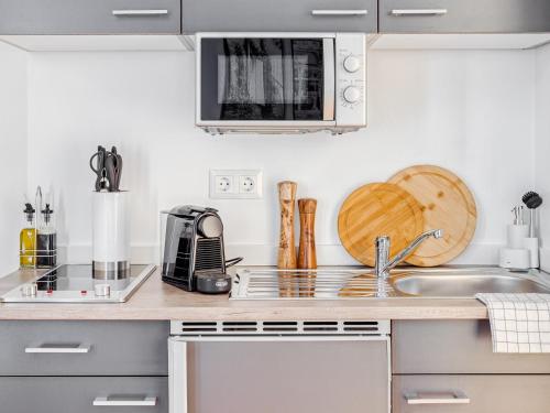 a kitchen with a sink and a microwave at Limehome Zwickau Hauptmarkt in Zwickau