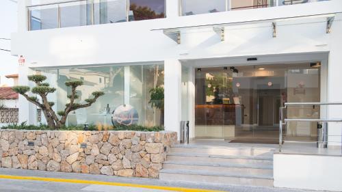 a store front of a building with a stone wall at Hotel Chevy & Suites in Cala Ratjada