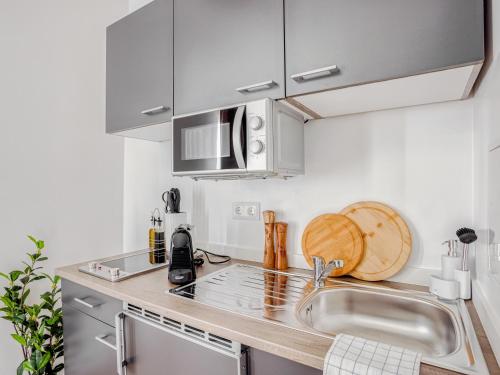 a kitchen with a sink and a counter top at Limehome Zwickau Hauptmarkt in Zwickau