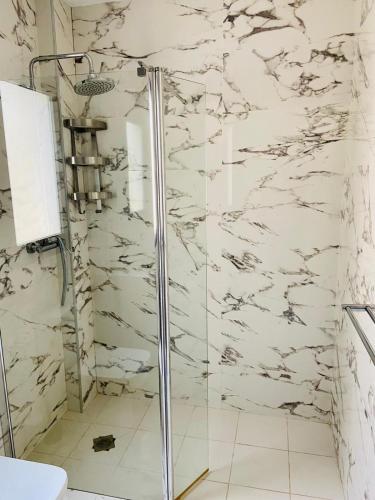 a bathroom with a shower with white marble walls at Luxury villa with private pool in Rojales