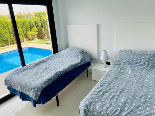 a bedroom with a bed and a view of a pool at Luxury villa with private pool in Rojales
