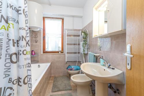 a bathroom with a sink and a toilet and a tub at Apartment Mirijana in Tar