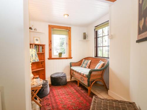 - un salon avec une chaise et une fenêtre dans l'établissement Garden Cottage, à Elgin