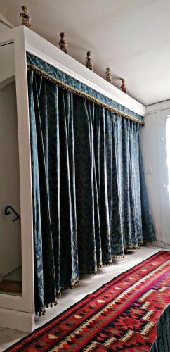 a living room with blue curtains and a rug at Casa Perni in Buccheri