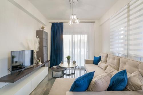 a living room with a white couch and blue pillows at Emerald Luxury Apartments in Nikiti