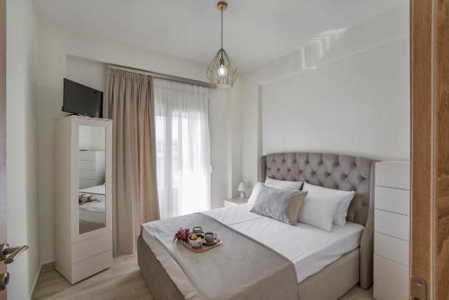 a bedroom with a bed with a tray of food on it at Emerald Luxury Apartments in Nikiti