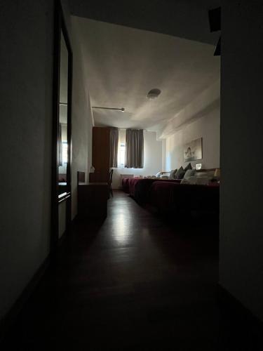 a dark room with two beds and a window at Hotel Cristallo Gran Sasso in LʼAquila