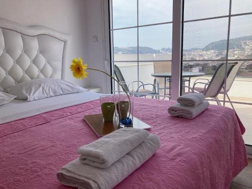 a bedroom with a pink bed with towels on it at Demiri Rr in Ulcinj