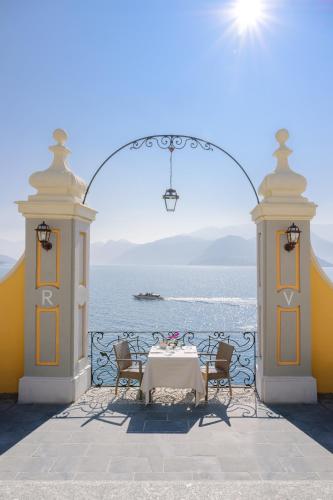 a table and chairs on a balcony with the ocean at Hotel Royal Victoria, by R Collection Hotels in Varenna