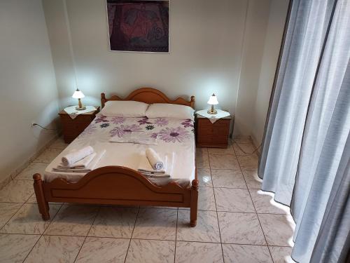 a bedroom with a bed with two tables and two lamps at 85 sqm Apartments New Panorama ELECTRIC CAR ΦΩΡΤΗΣΗΣ STATION in Paralion astros
