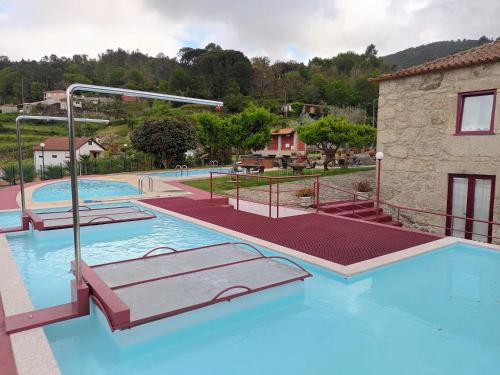 a swimming pool with two slides in a resort at Casa D`Auleira in Ponte da Barca