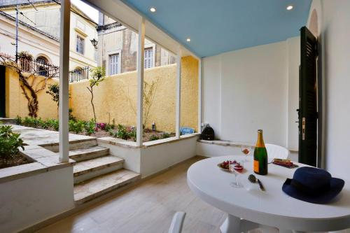 Habitación con mesa y botella de vino en Τhe Hidden Garden en Corfú