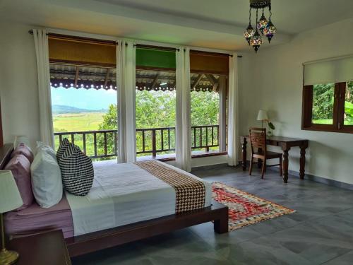 a bedroom with a bed and a large window at Alamanda Villas Langkawi in Kuah