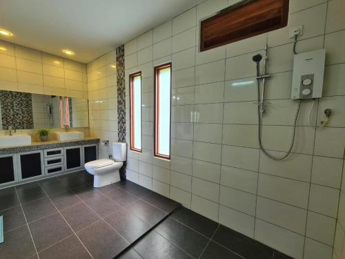 uma casa de banho com um WC, um lavatório e um chuveiro em Alamanda Villas Langkawi em Kuah
