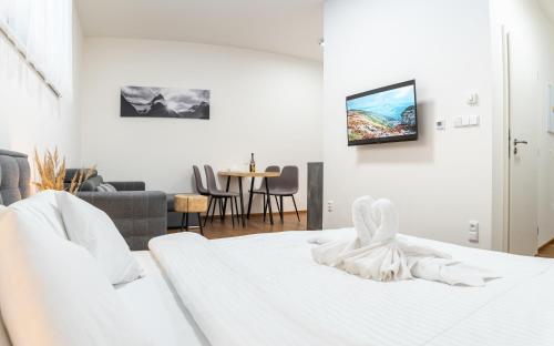 - une chambre blanche avec un lit blanc et une table dans l'établissement Apartmán Vrchlabí Krkonoše, à Vrchlabí
