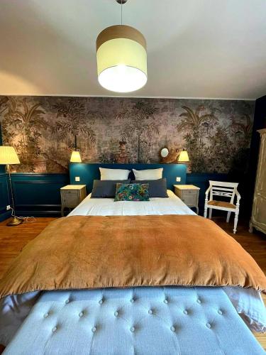 a bedroom with a large bed with blue walls at NAMASTE COTTAGE in Issigeac