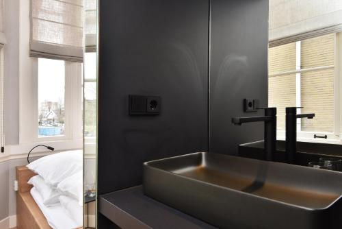 uma casa de banho com um grande lavatório e um espelho em Boutique Hotel Havenkantoor em Haia