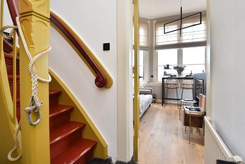 a hallway with a yellow staircase in a house at Boutique Hotel Havenkantoor in The Hague