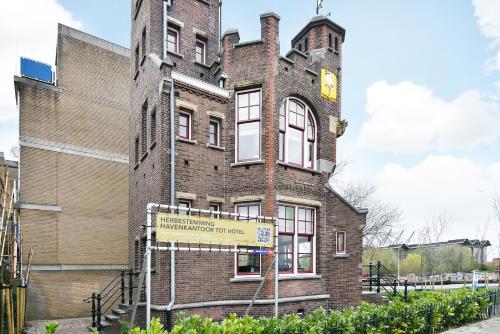 a brick building with a sign in front of it at Boutique Hotel Havenkantoor in The Hague
