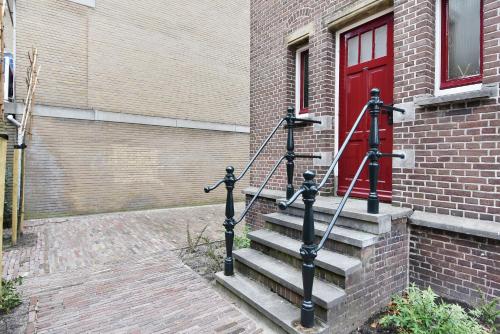 a set of stairs in front of a building with a red door at Boutique Hotel Havenkantoor in The Hague