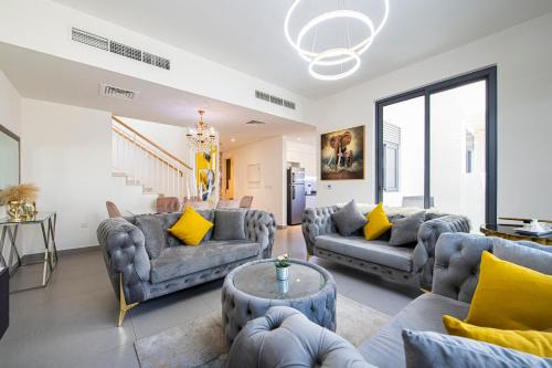 a living room with two couches and a table at Modern Dubai Hills Luxury 4 BEDROOM VILLA in Dubai