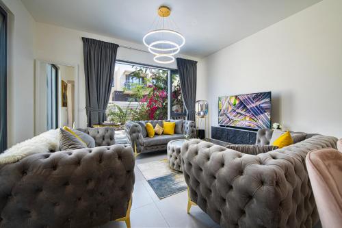 a living room with couches and yellow pillows at Modern Dubai Hills Luxury 4 BEDROOM VILLA in Dubai