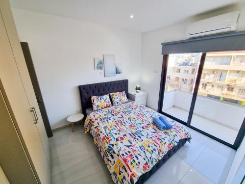 a bedroom with a bed and a large window at Sea La Vie Seaview Apartment in Larnaka