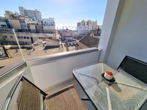 a table on a balcony with a view of a city at Sea La Vie Seaview Apartment in Larnaka