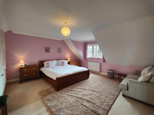 - une chambre avec un grand lit et un canapé dans l'établissement Birdsong Rural Winchester Twyford - 2BR, 5BR, 7BR - sleeps upto 16, à Winchester
