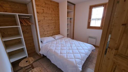 une chambre avec un lit blanc dans une pièce dans l'établissement Apprt 41m2 6 pers avec 2 chambres, 1 coin montage avec garage, à Les Deux Alpes