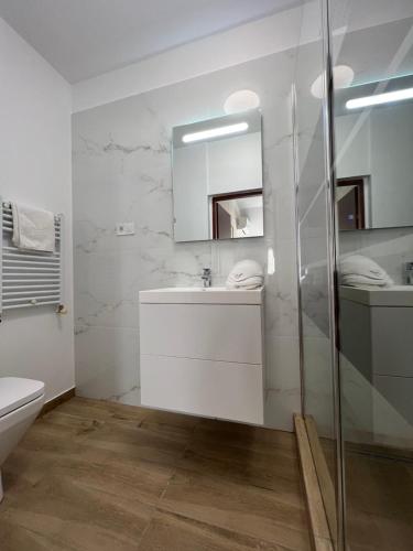 a white bathroom with a sink and a mirror at Casa Mignon in Oradea