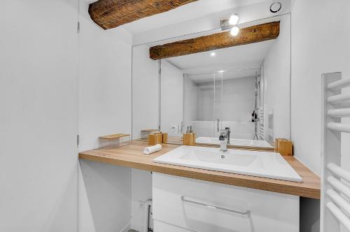 a white bathroom with a sink and a mirror at LE CONSTANTIN - Charmant souplex de 34m2 in Toulouse