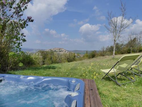 una sedia e una vasca idromassaggio in un campo di Détente à Cordes-sur-ciel, vue magnifique, SPA a Souel-et-Sarmases
