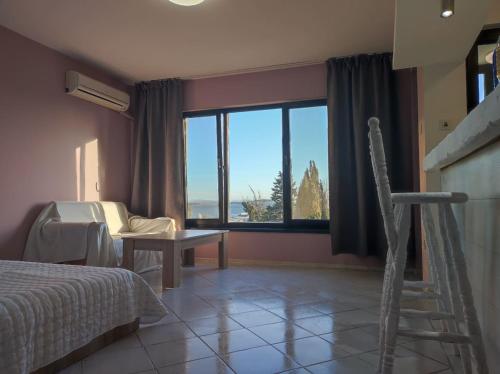 a bedroom with a bed and a large window at Sunrise Apartment in Burgas