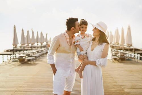 a woman and a man and a child standing on a pier at Akka Antedon Hotel - Premium Ultra All Inclusive in Beldibi