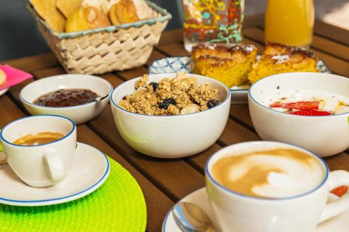 a wooden table topped with cups of coffee and pastries at Sa Crai B&B - Sardinian Experience in Lotzorai