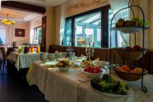 a table with bowls of fruits and vegetables on it at Hotel Nordstern in Neuharlingersiel