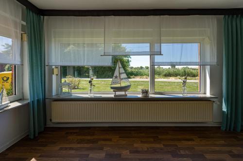 a window with a window sill with a boat on it at Hotel Nordstern in Neuharlingersiel