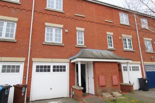 a brick building with two white garage doors at AMAZING 7 PERSON 3 BEDROOM 3 BATHROOM HOUSe in Hull