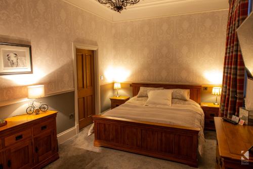 a bedroom with a large bed and two night stands at Herdwicks in Millom