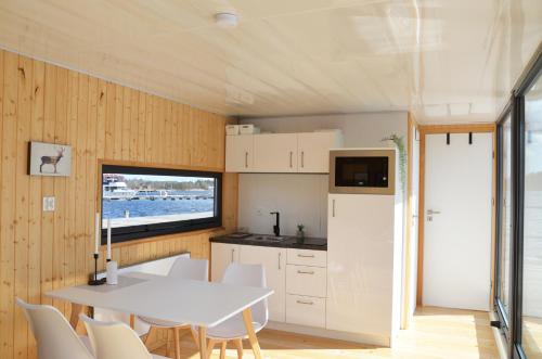 una cucina e una sala da pranzo di una casetta di Schwimmendes Haus, freier Blick aufs Wasser im Schärengebiet Blankaholm inkl Boot a Blankaholm