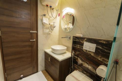 a bathroom with a sink and a toilet and a mirror at Hotel Yog Vashishth in Rishīkesh
