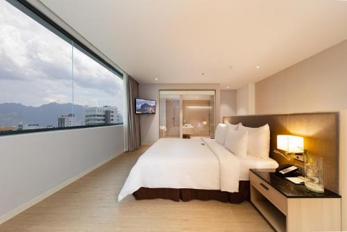a bedroom with a large bed and a large window at DQua Hotel in Nha Trang